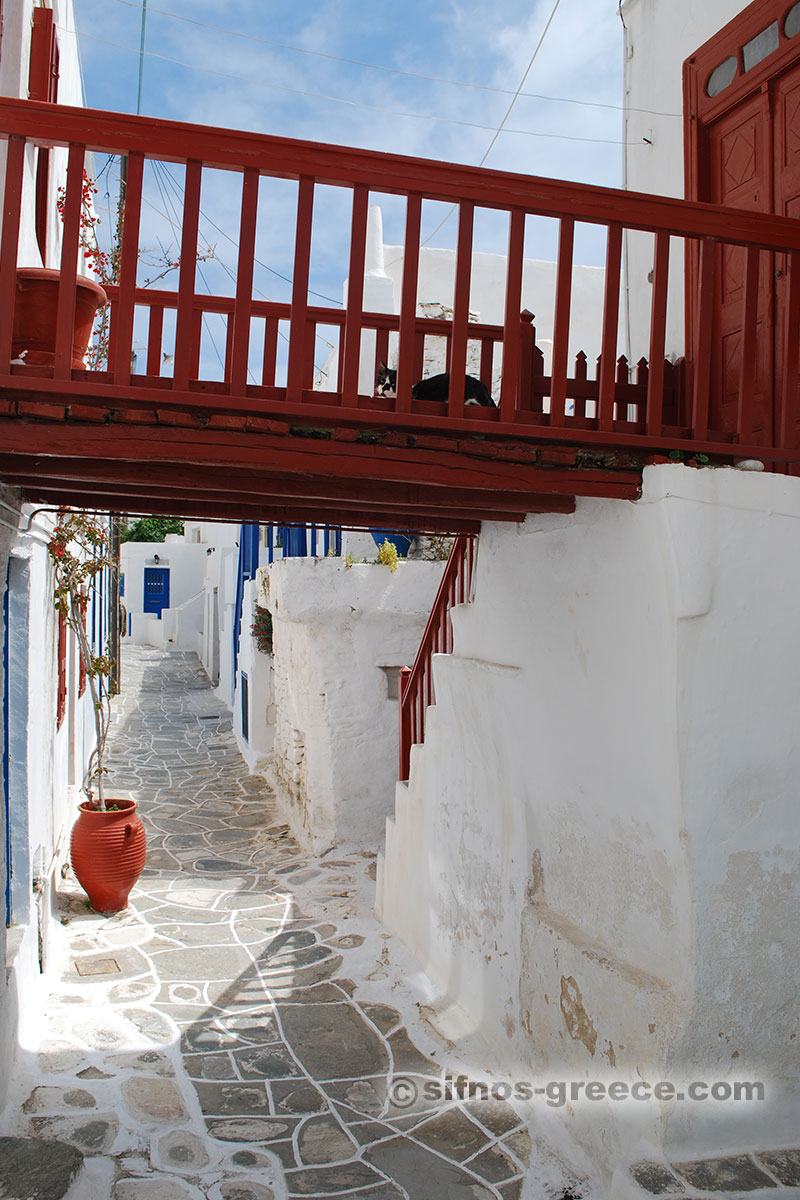 En röd balkong i ett hus i Kástro